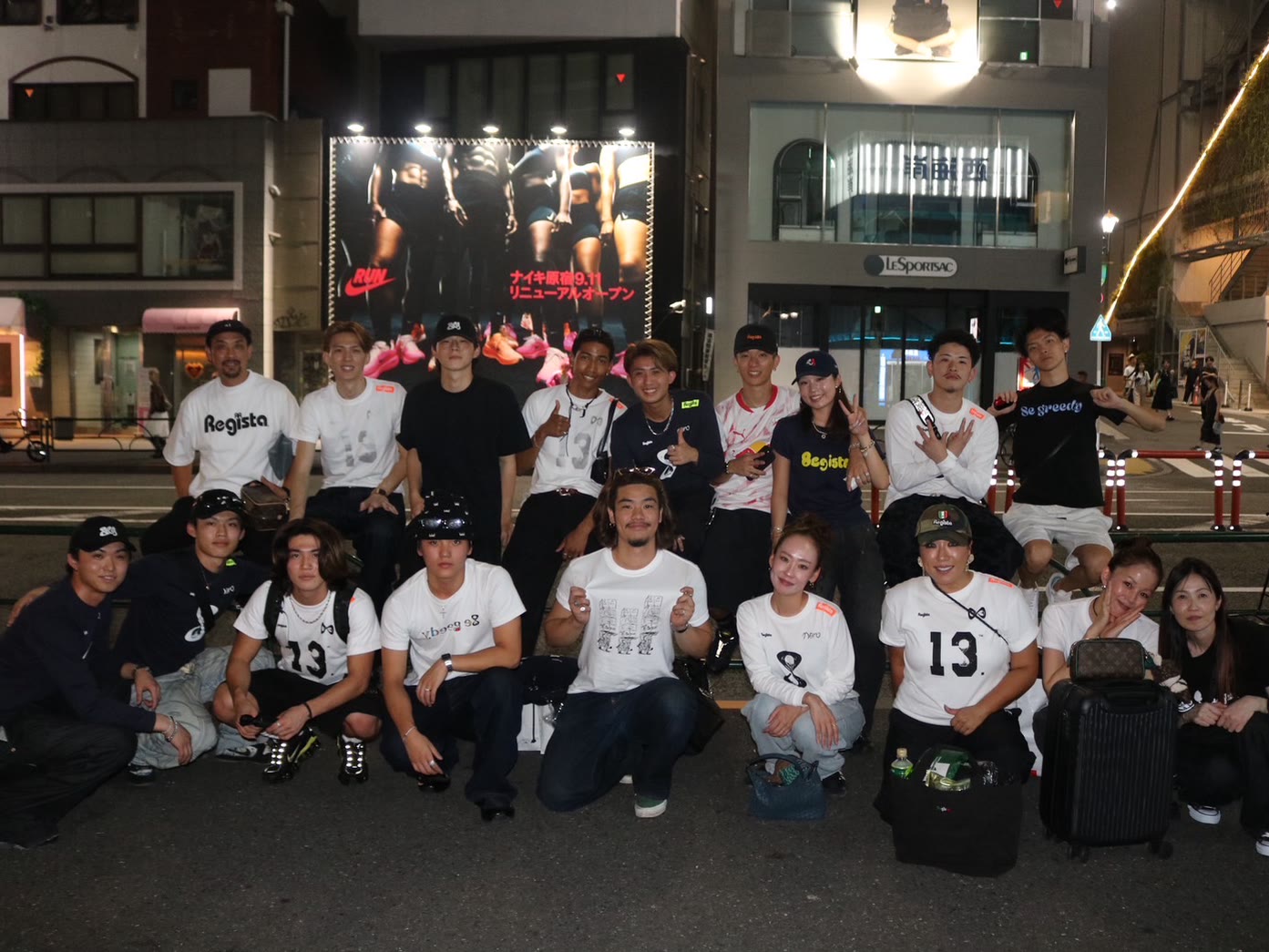 自社ブランドのアパレルを着たメンバーが夜の街で並ぶ集合写真