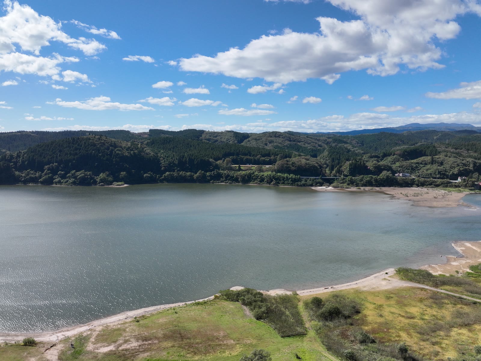 ドローンで空撮した、山あいの湖と緑の稜線